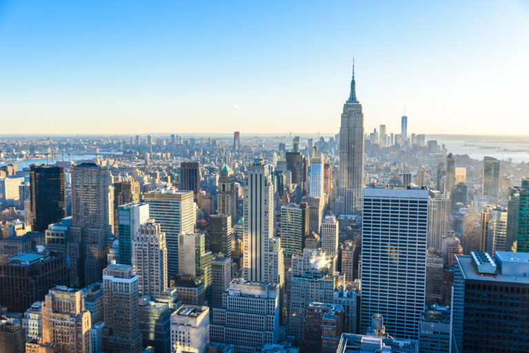 New York City - USA. View to Lower Manhattan downtown skyline with famous Empire State Building and skyscrapers at sunset.